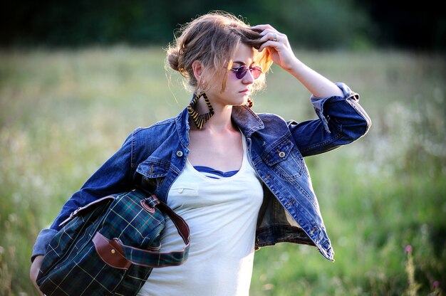 Mulher bonita yang vestida de maneira vintage caminhando ao ar livre no verão