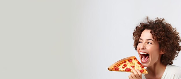 Foto mulher branca feliz comendo pizza e gesticulando em direção ao espaço vazio em um fundo branco com sala de vista panorâmica de anúncio de fast food para texto