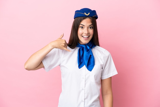 Foto mulher brasileira aeromoça de avião isolada no fundo rosa fazendo gesto de telefone. ligue-me de volta sinal