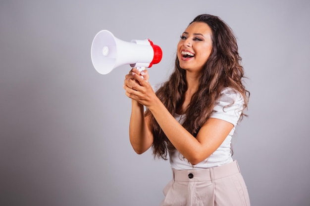 Mulher brasileira cabelo castanho segurando megafone anunciando promoção de desconto Gritando e ligando