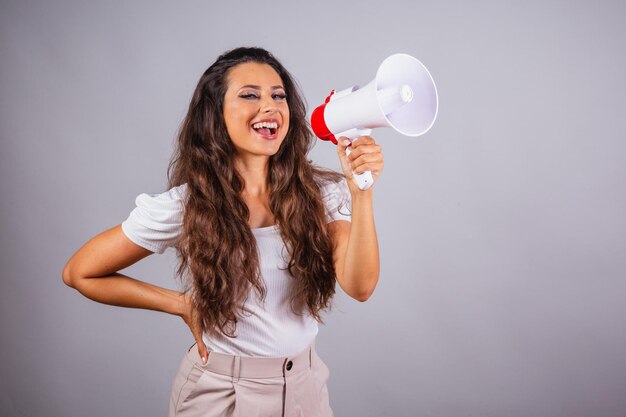 Mulher brasileira cabelo castanho segurando megafone anunciando promoção de desconto Gritando e ligando