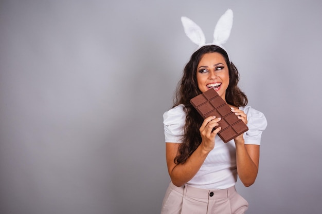 Mulher brasileira com orelhas de coelho e barra de chocolate