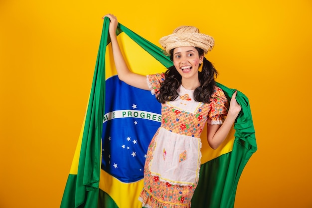 Foto mulher brasileira com roupas de festa junina com bandeira do brasil