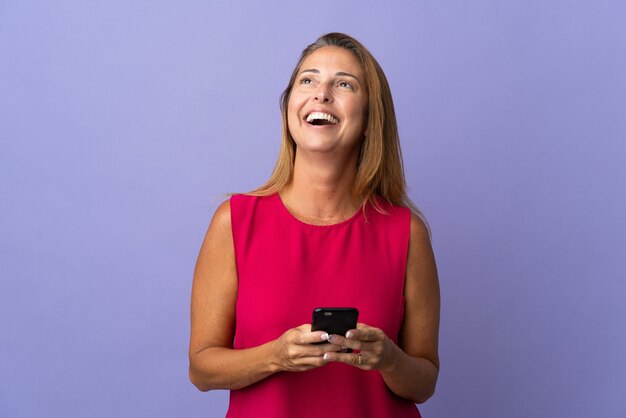 Mulher brasileira de meia-idade isolada usando celular e olhando para cima