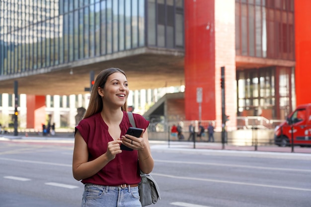 Foto mulher brasileira sorridente pára um veículo usando um aplicativo móvel esperando um táxi ou uber na avenida paulista, são paulo, brasil