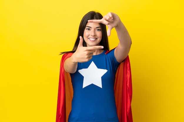 Foto mulher brasileira super-herói isolada no rosto de foco de fundo amarelo. símbolo de enquadramento