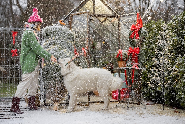 Mulher brinca com seu cachorro durante as férias de inverno no quintal