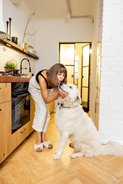 Mulher brinca com seu cachorro enquanto cozinha