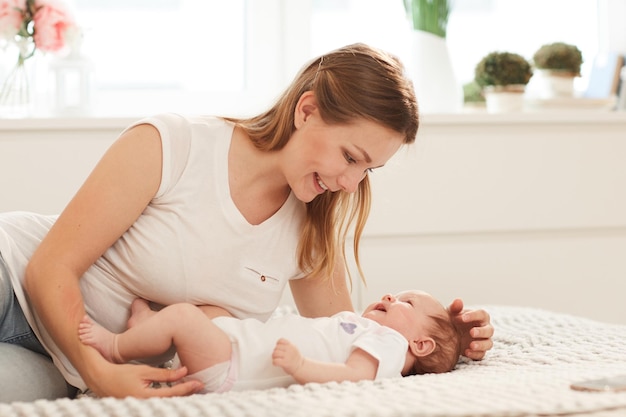 Mulher brincando com criança recém-nascida