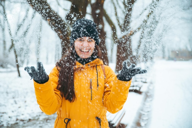 Mulher brincando com neve no parque da cidade nevada