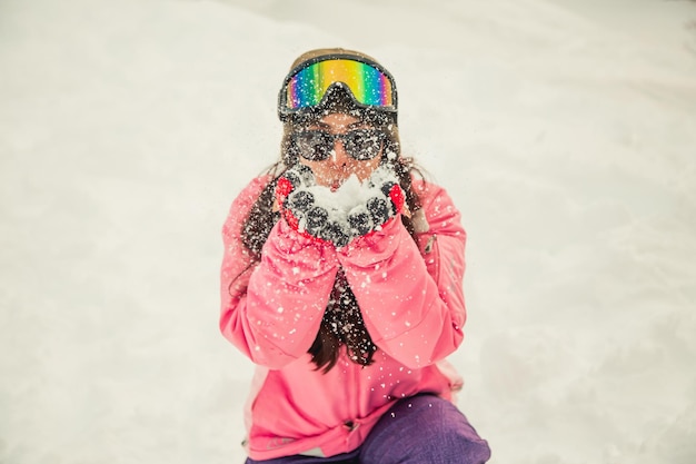 Mulher brincando com neve vestindo roupas de neve