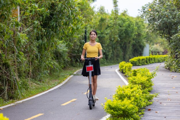 Mulher brincando com scooter no parque