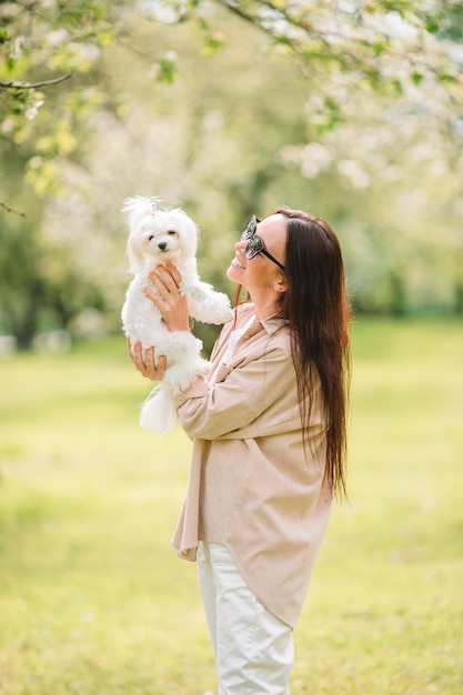 Mulher brincando e abraçando cachorrinho no parque