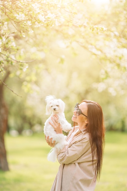 Mulher brincando e abraçando cachorrinho no parque