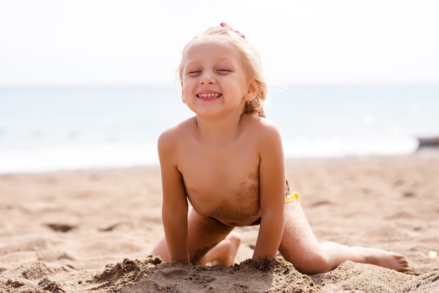 Mulher brincando na areia perto do mar