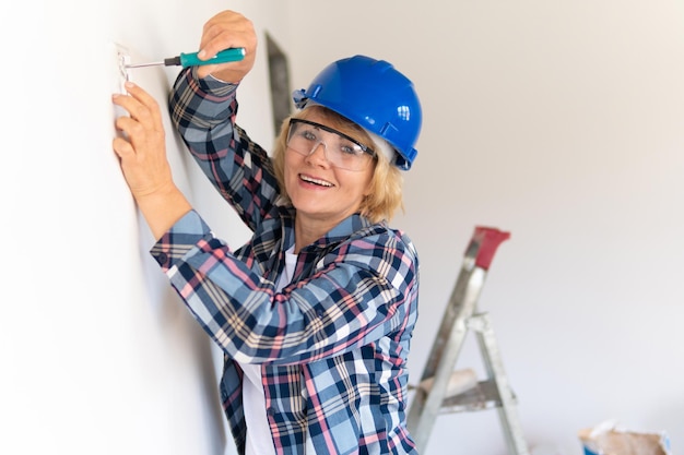 Mulher builder na sala da casa fazendo reparos