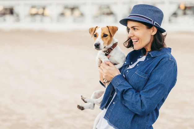 Mulher caminha com cachorro pequeno