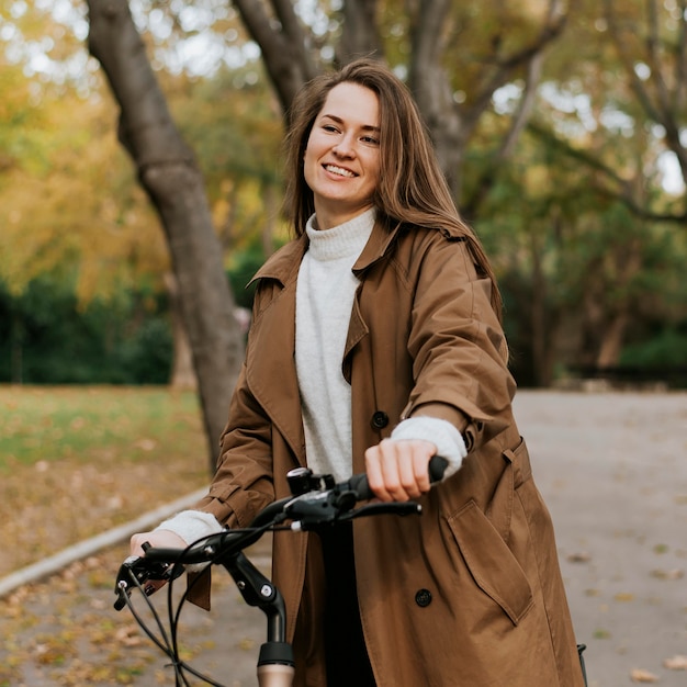 Foto mulher caminhando ao lado de sua bicicleta