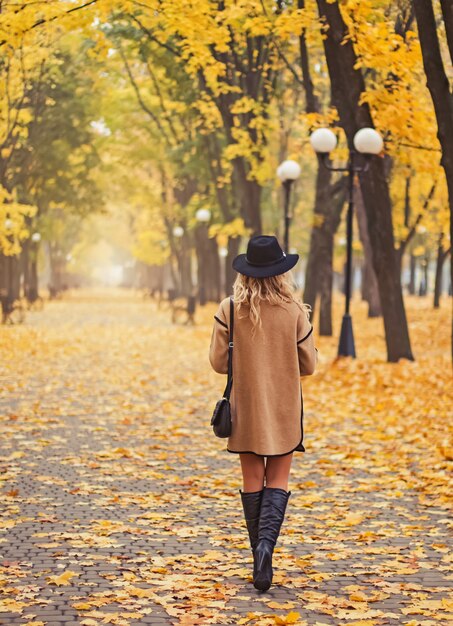 Mulher caminhando em lindo parque de outono