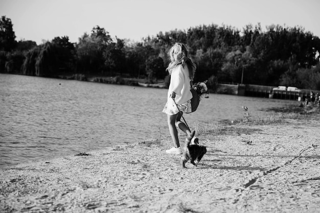 Mulher caminhando na praia com gatinho