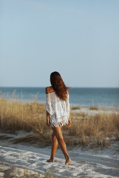 Mulher caminhando na praia durante as férias