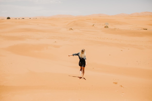 Mulher caminhando no deserto em um dia ensolarado