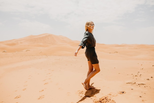 Mulher caminhando no deserto em um dia ensolarado