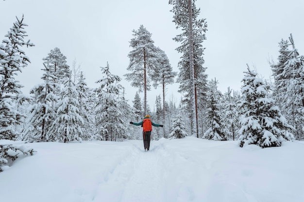 Mulher caminhando pela lapônia coberta de neve, finlândia