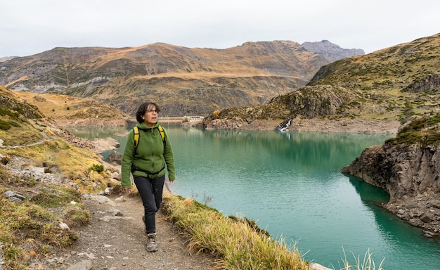 Mulher caminhando perto de um lago de montanha