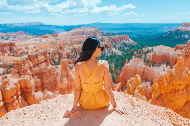 Mulher caminhante em Bryce Canyon descansando desfrutando de uma vista em uma bela paisagem natural com pináculos de hoodoos e torres formações rochosas em Utah