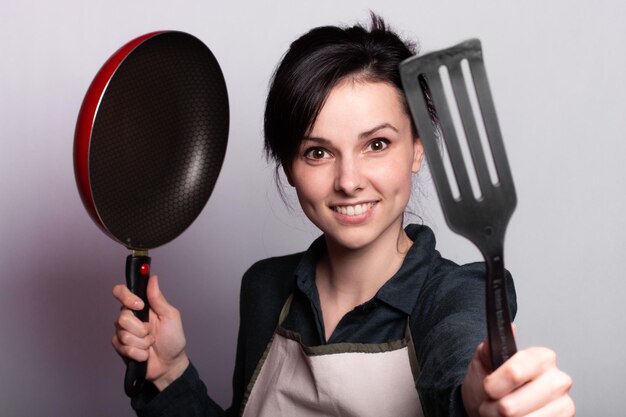 mulher cansada de cozinhar com pratos nas mãos