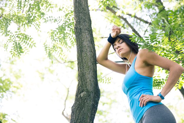 Mulher cansada de fitness descansando ao ar livre