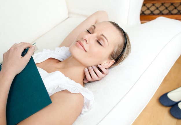 Mulher cansada dormindo enquanto lê um livro