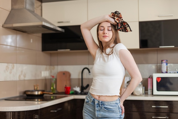 Foto mulher cansada limpa a cozinha segurando pano limpeza da casa