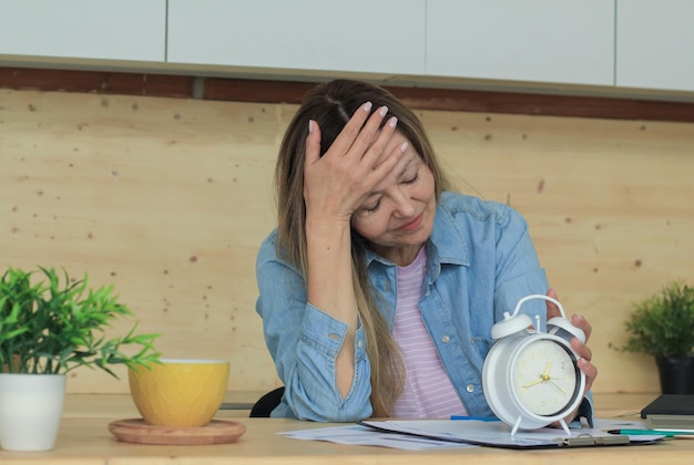 Mulher cansada no escritório dormindo em cima da mesa, muito trabalho, esgotamento emocional, estresse