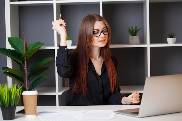 Mulher cansada, trabalhando no computador no escritório