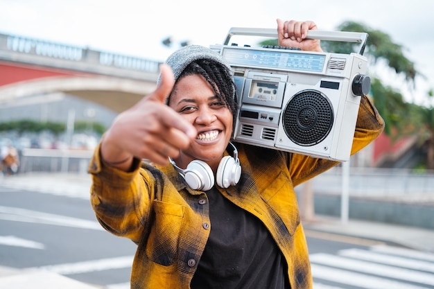 Mulher cantando hiphop com o rádio cassette no ombro para rimar ao ar livre Conceito Cantando estilo de vida livre