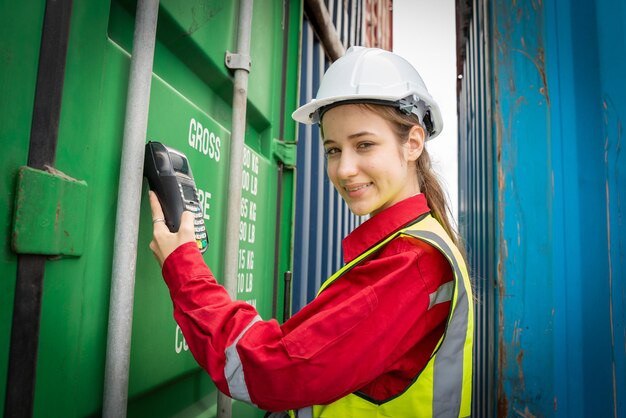 Foto mulher capataz e operador usando máquina de cartão de crédito para verificar o código do contêiner de carga antes da importação exprot conceito logística transporte transporte lady foreman verificando o armazém de carga