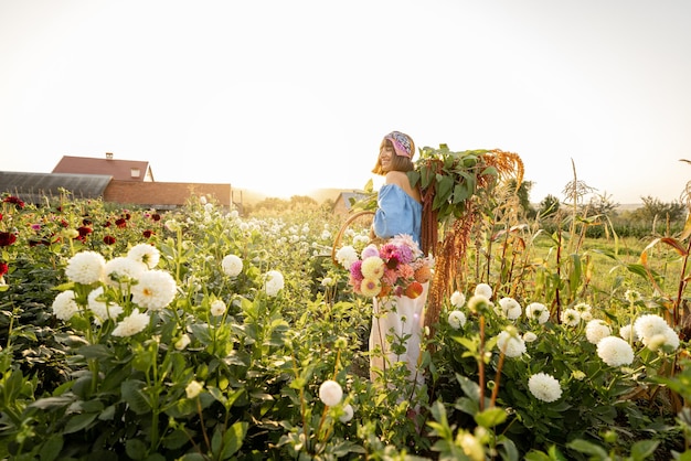 Mulher carrega muitas flores recém-colhidas na fazenda