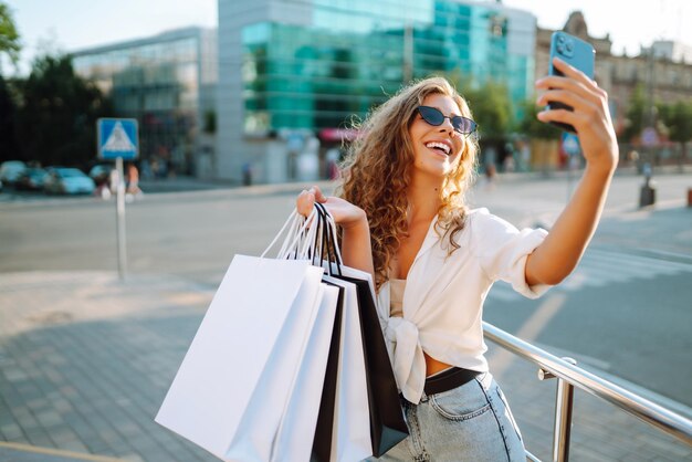 Mulher carregando algumas bolsas de compras andando na rua da cidade Black Friday Compras conceito de estilo de vida