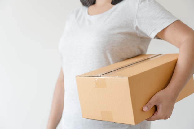 Mulher carregando caixa de papelão para entrega de encomendas