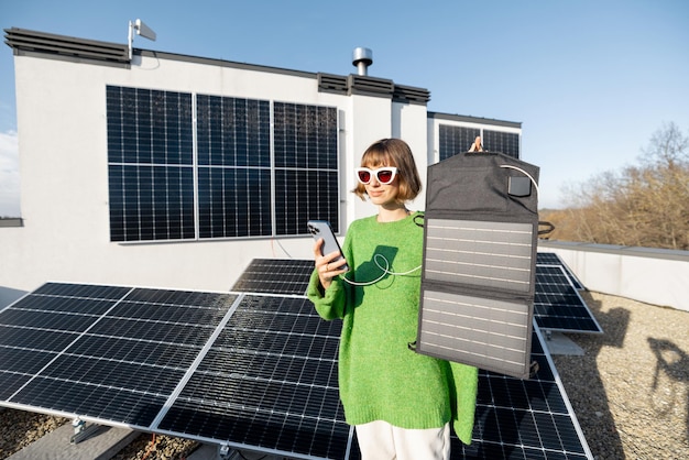 Mulher carregando telefone de um painel solar portátil