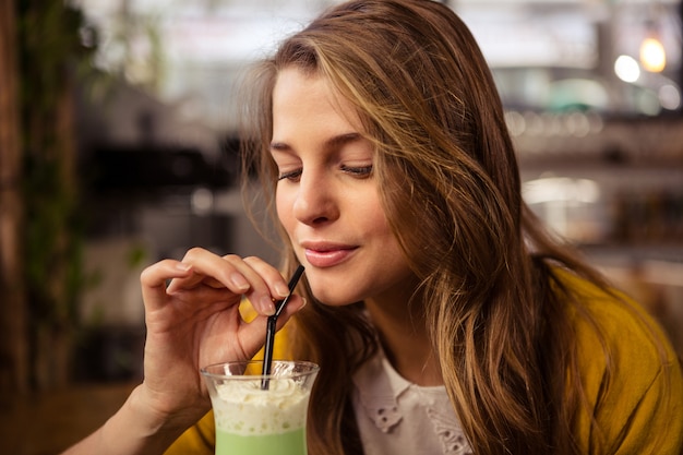 Mulher casual, beber um cocktail