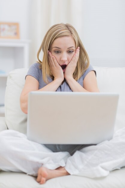 Mulher casual chata olhando a tela do laptop em casa