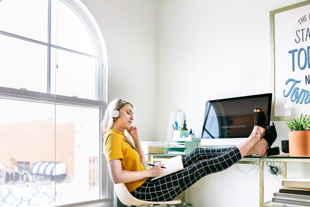 Mulher casual em um escritório com fones de ouvido