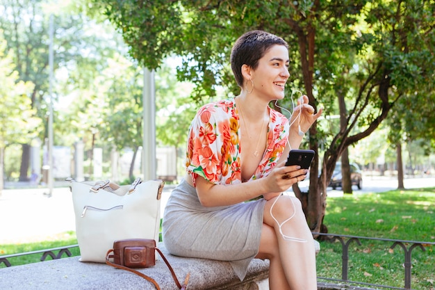 Mulher casual, usando a tecnologia no parque