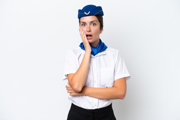 Mulher caucasiana com aeromoça de avião isolada no fundo branco surpresa e chocada ao olhar para a direita
