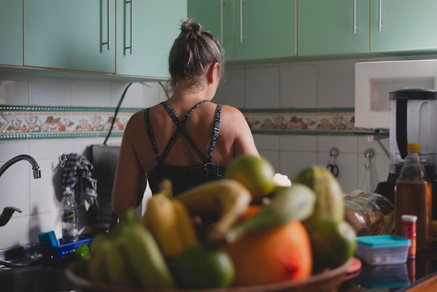 Foto mulher caucasiana com as costas para a cozinha na cozinha