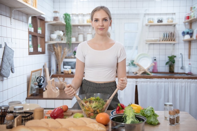 Mulher caucasiana, cozinhar alimentos na cozinha.