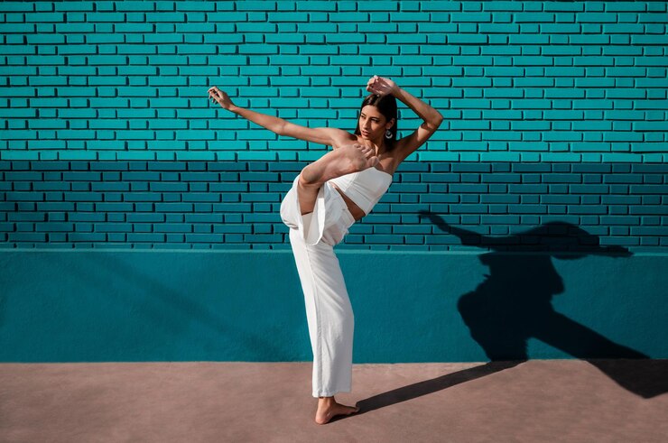 Foto mulher caucasiana dançando dança urbana com luz do dia e um fundo verde